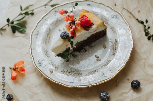 Käsekuchen mit frischen Beeren auf einem Vintage Teller, Frühlings-Käse-Schkokuchen