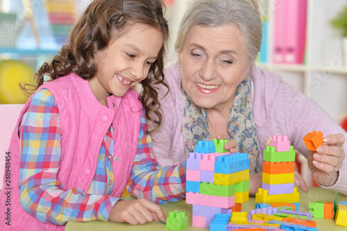 Close up portrait of cute girl and grandmother playing