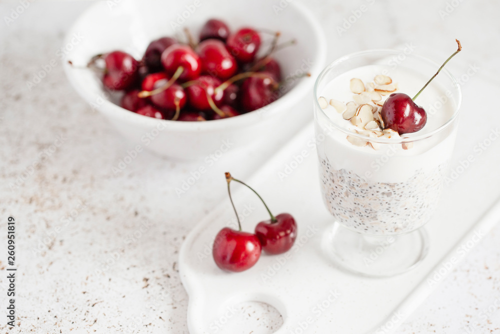 yogurt with chia seeds, oatmeal and cherries on a light background yogurt with chia seeds, oatmeal and cherries on a light background