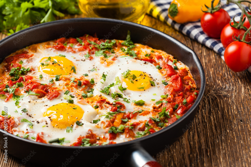 Shakshouka, dish of eggs poached in a sauce of tomatoes, chili peppers, onions Shakshouka, dish of eggs poached in a sauce of tomatoes, chili peppers, onions