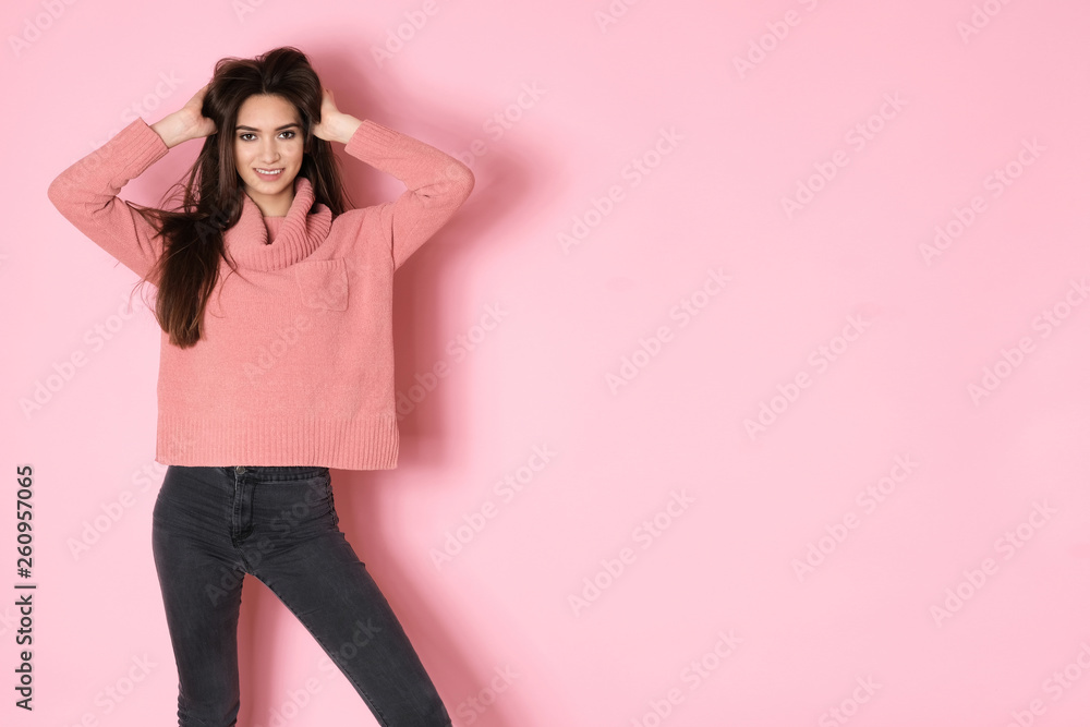 Pretty young girl full of energy posing in pink sweater on pink background Pretty young girl full of energy posing in pink sweater on pink background
