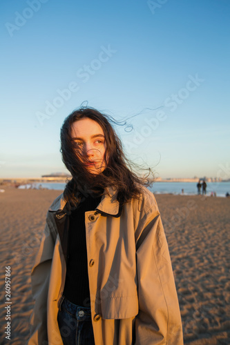 Pleasing girl portrait in wearing a cloak  on the autumn sea coast.
