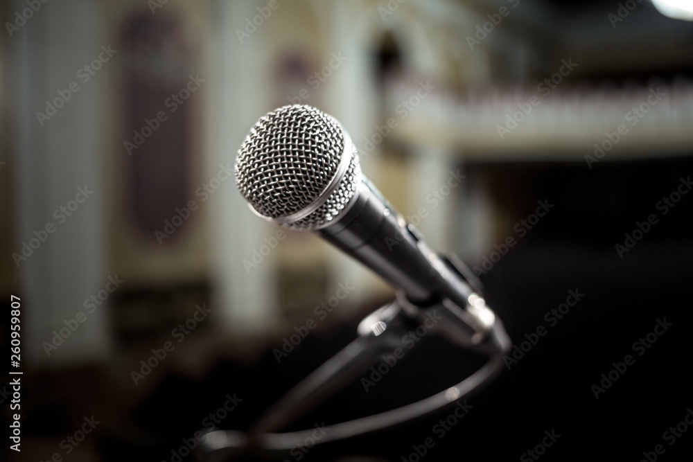 Microphone over the Abstract blurred photo of conference hall or seminar room background Microphone over the Abstract blurred photo of conference hall or seminar room background