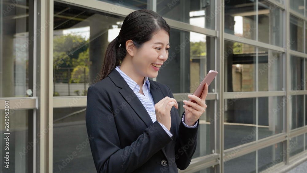 authentic lifestyle. smiling business woman boss portrait in black suit standing outside office building skyscraper texting message chatting on cellphone after work. young lady worker enjoy sunset. authentic lifestyle. smiling business woman boss portrait in black suit standing outside office building skyscraper texting message chatting on cellphone after work. young lady worker enjoy sunset.