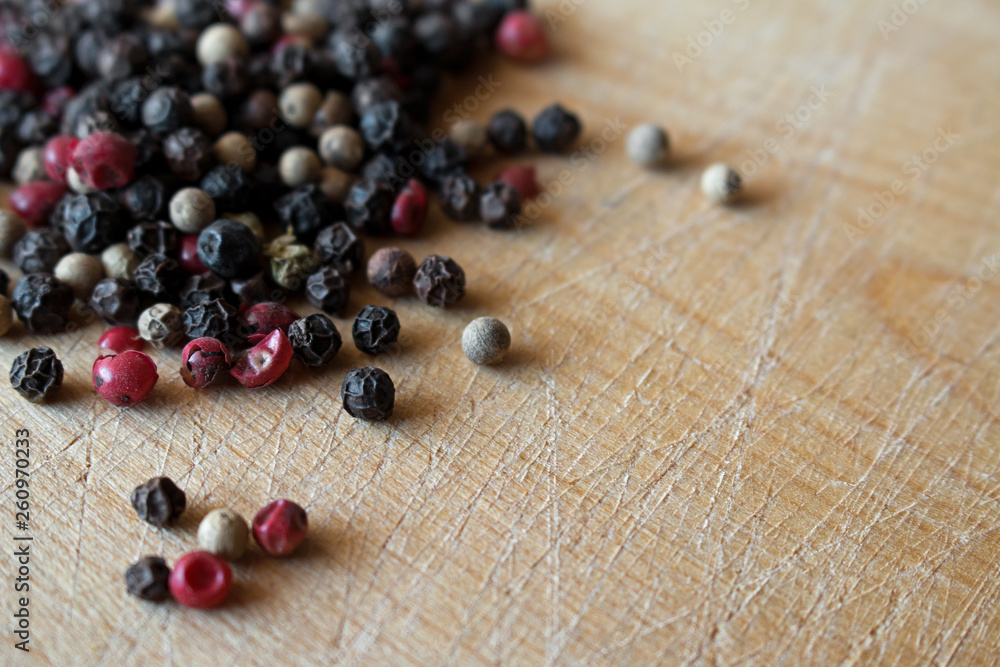 Mixed peppercorns on wooden surface. Selective focus. Mixed peppercorns on wooden surface. Selective focus.