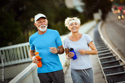 Fototapeta Naklejka Na Ścianę i Meble -  Happy senior couple staying fit by sport running