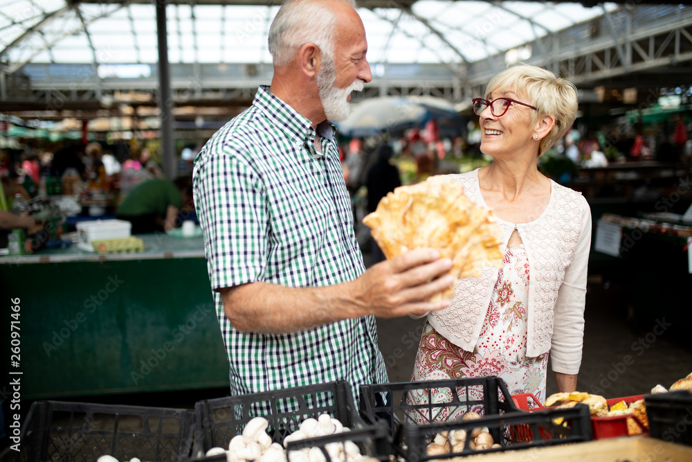 Portrait of beautiful elderly couple in market buing food