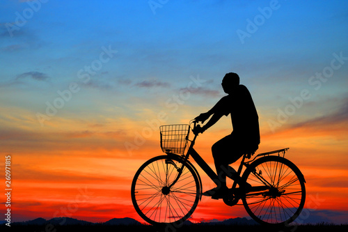 Silhouette man  and bike relaxing on blurry sky   background.