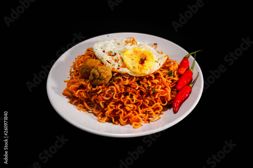 Spicy Noodle with meatball and fried egg isolated on black background