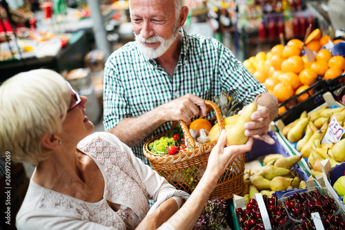 Smiling senior couple buying vegetables and at the merket photo
