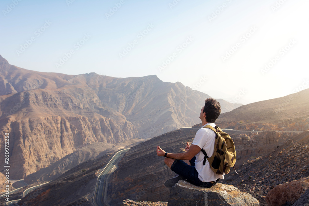 Fototapeta premium Man meditating on the mountain top