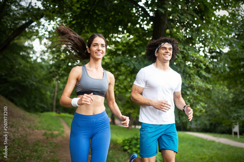 Fototapeta Naklejka Na Ścianę i Meble -  fitness, sport, friendship and lifestyle concept - smiling couple exercising outdoors