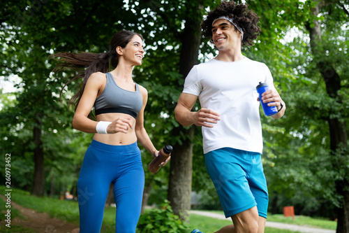 fitness, sport, friendship and lifestyle concept - smiling couple exercising outdoors