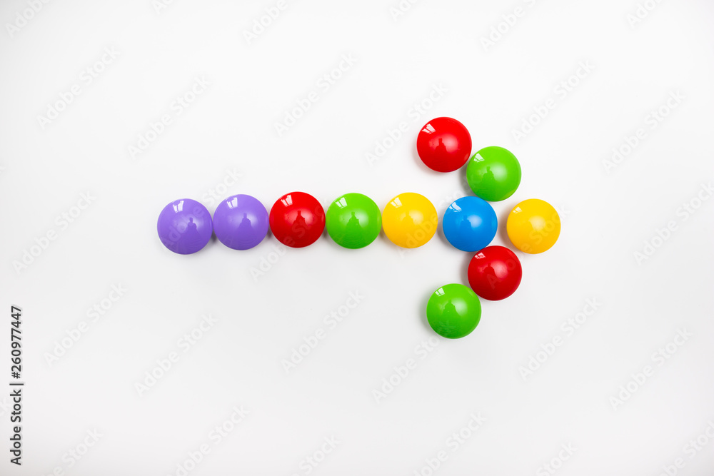 A pointing arrow made from children's toys. Multicolored figures for games A pointing arrow made from children's toys. Multicolored figures for games