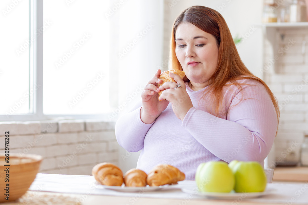 Nice thoughtful woman looking at the apple Nice thoughtful woman looking at the apple