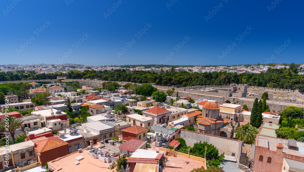 Panoramic view of the Rhodes medieval old city surrounded by ancient stone defensive walls, with the new town and Acropolis in the background. Popular summer holiday destination in the Greece.
