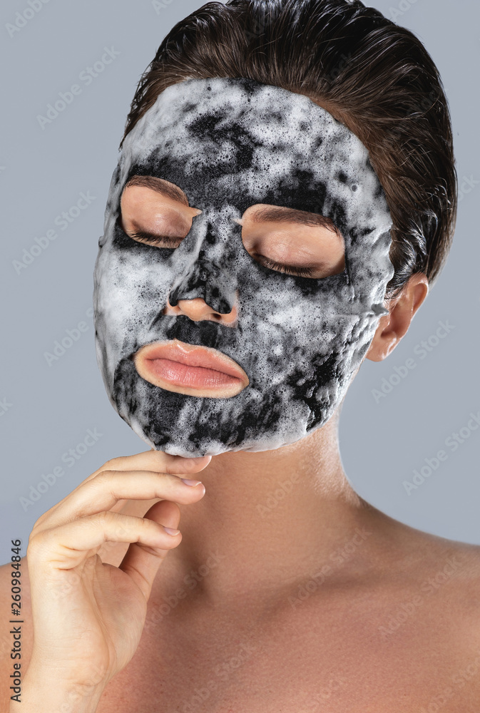 Fototapeta premium Woman with bubble sheet mask on her face