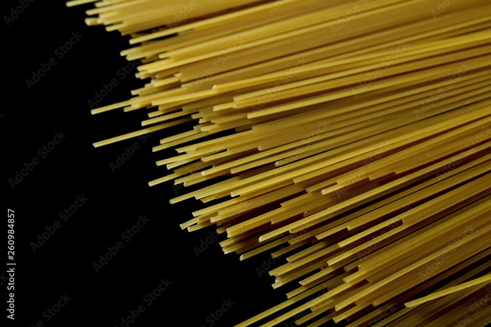 Fototapeta premium Spaghetti, yellow pasta isolated on black background, clipping path