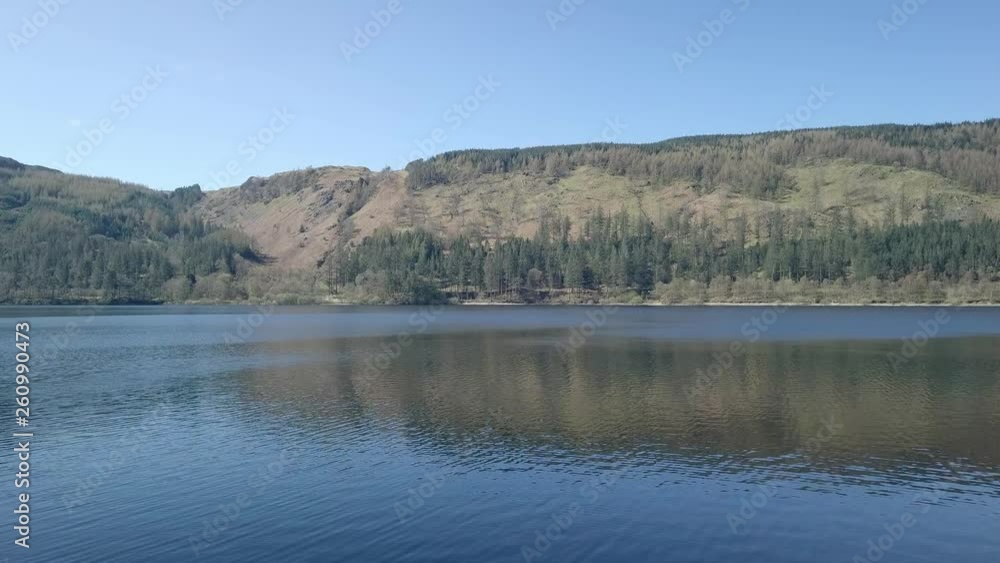 Aerial view across Thirlmere reservoir in the Lake District national park. Dense thick woodlands surrounding reflecting deep blue waters. Aerial view across Thirlmere reservoir in the Lake District national park. Dense thick woodlands surrounding reflecting deep blue waters.