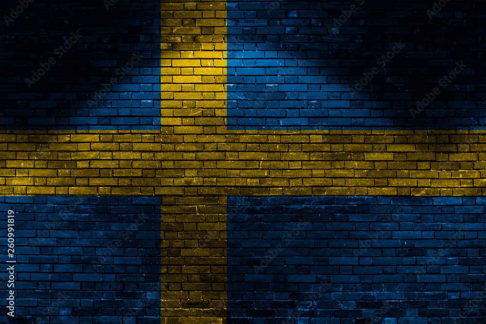 Sweden flag on brick wall at night
