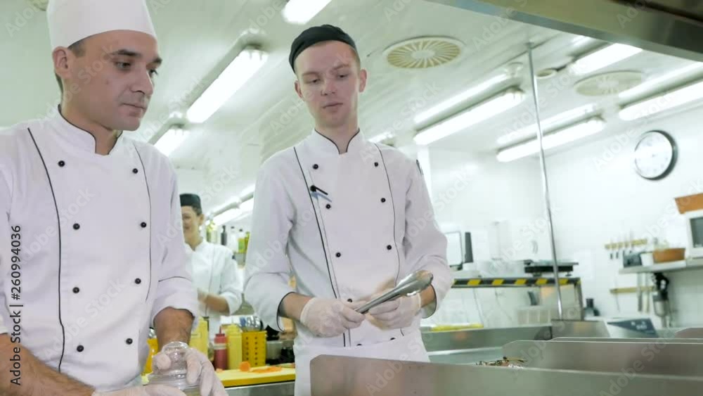 Chef spreading peppers on meat for preparing food Chef spreading peppers on meat for preparing food