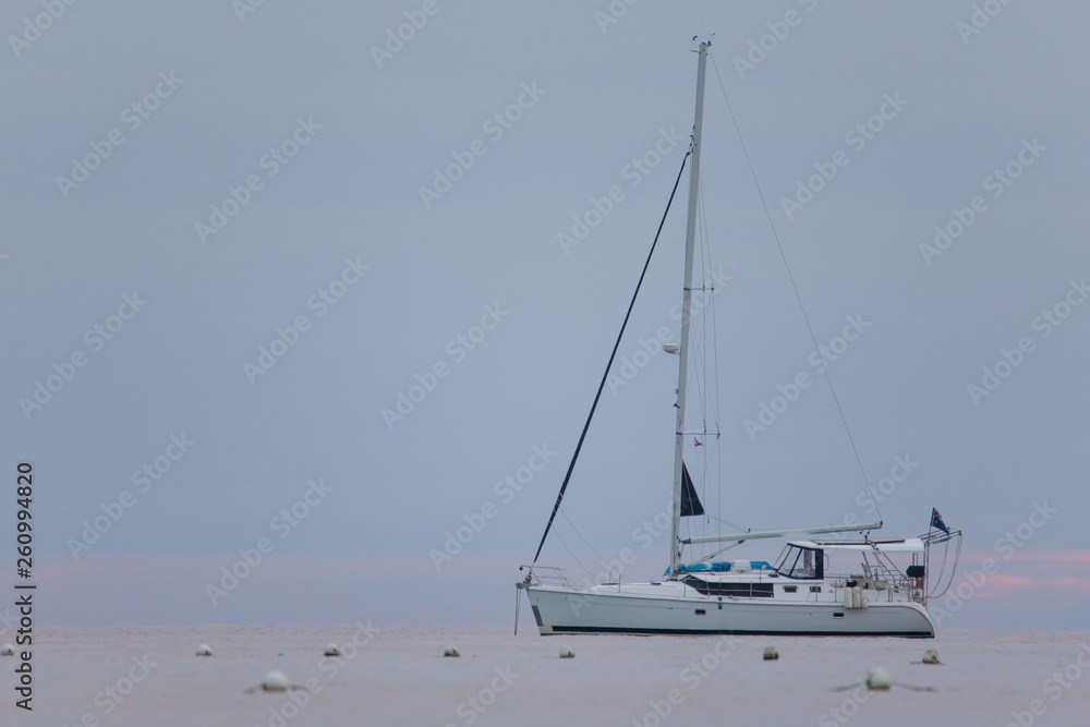 Fototapeta premium Sailing Boat Sailboat anchoring infront the white beach a Tranquil seascape scene with calm sea