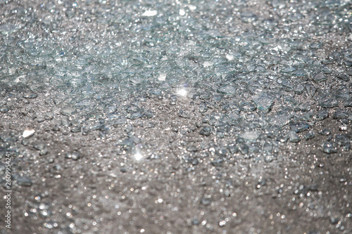 Shards of broken car glass on the asphalt road