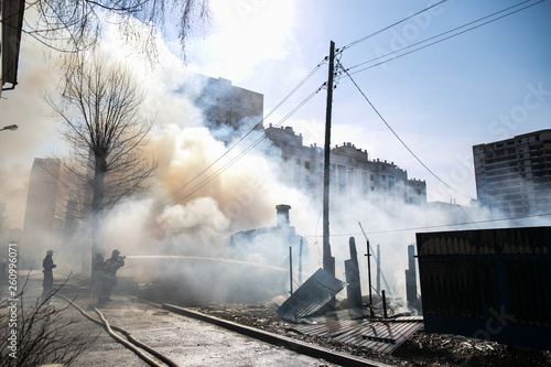Fireman spraying water in a smouldering burnt out house © Семен Саливанчук