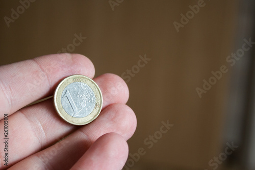 hand with 1 euro coin