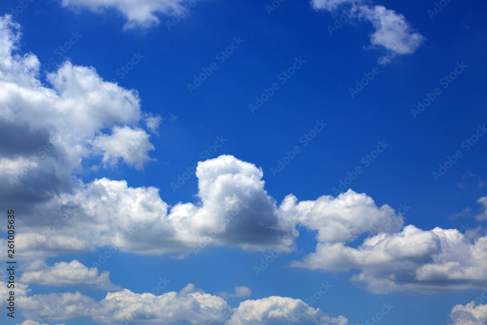 Fototapeta premium Big white fluffy clouds in the blue sky.Summer background.