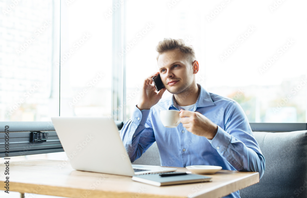 Stylish young man calling by the phone to solve business problems. Online consultation by phone. Freelancer discussing the development and planning of his online project. Outsourcing. Mobile services. Stylish young man calling by the phone to solve business problems. Online consultation by phone. Freelancer discussing the development and planning of his online project. Outsourcing. Mobile services.