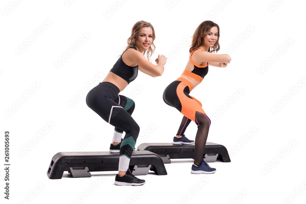Two slim women in sportswear doing fitness view Two slim women in sportswear doing fitness view