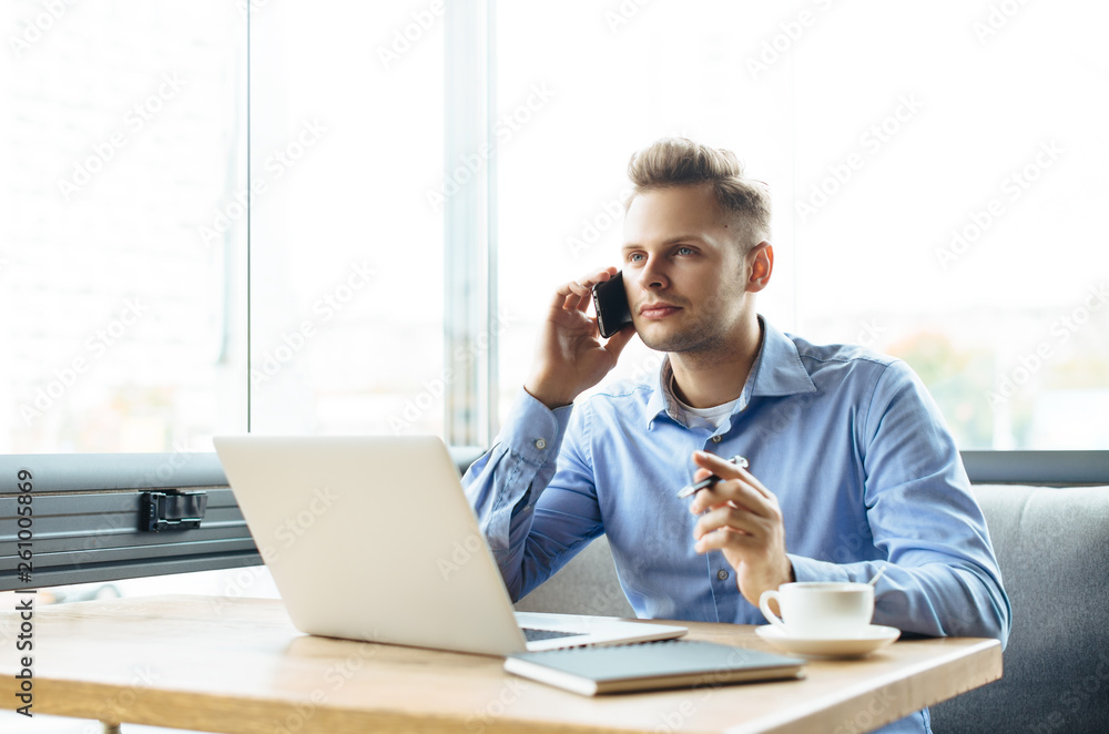Stylish young man calling by the phone to solve business problems. Online consultation by phone. Freelancer discussing the development and planning of his online project. Outsourcing. Mobile services. Stylish young man calling by the phone to solve business problems. Online consultation by phone. Freelancer discussing the development and planning of his online project. Outsourcing. Mobile services.