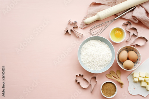 Baking ingredients and utensils on pink background. Cooking or baking cake, cookies, pastry concept. Top view, copy space photo