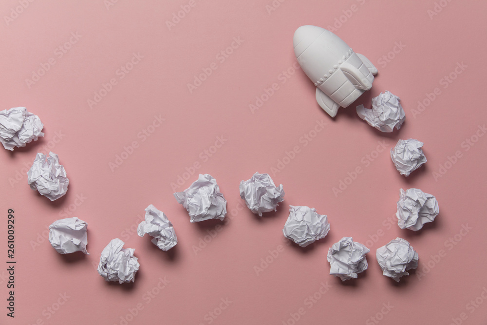 Business startup concept. Rocket taking off with crumpled paper trail Business startup concept. Rocket taking off with crumpled paper trail