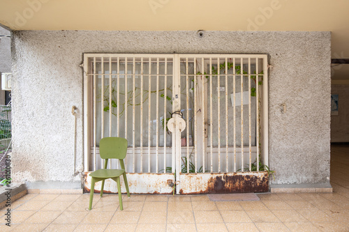 A green chair in front of an old building entrance photo