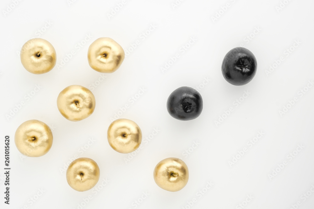 Golden and black apples on white background. Two groups, comparison and opposition. Golden and black apples on white background. Two groups, comparison and opposition.
