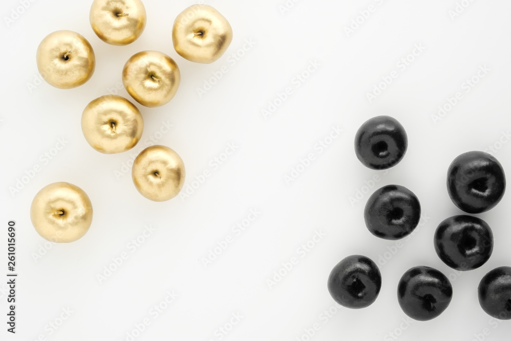 Golden and black apples on white background. Two groups, comparison and opposition. Golden and black apples on white background. Two groups, comparison and opposition.