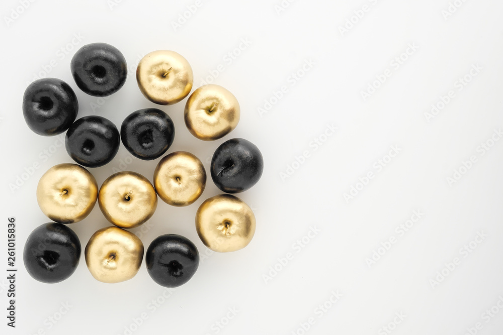 Golden and black apples on white background. Two groups, comparison and opposition. Golden and black apples on white background. Two groups, comparison and opposition.