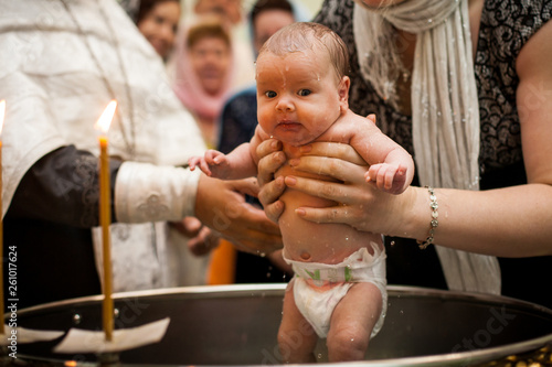 Newborn baby baptism in Holy water Fototapeta