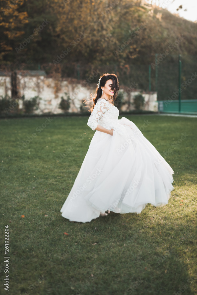 Beautiful bride spinning with perfect dress in the park Beautiful bride spinning with perfect dress in the park