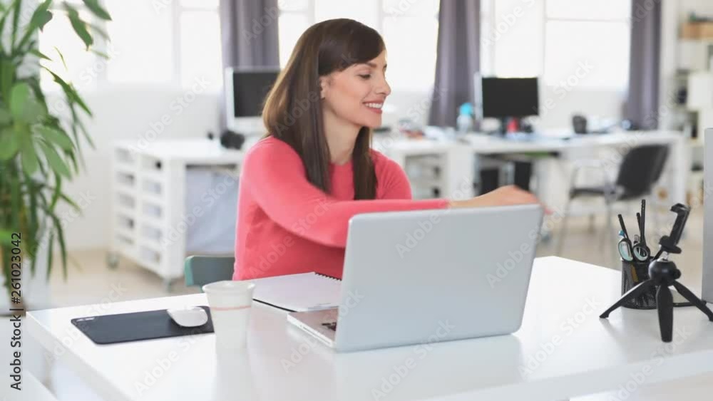 Young beautiful Caucasian businesswoman with brown hair sitting in office and using laptop. Young beautiful Caucasian businesswoman with brown hair sitting in office and using laptop.