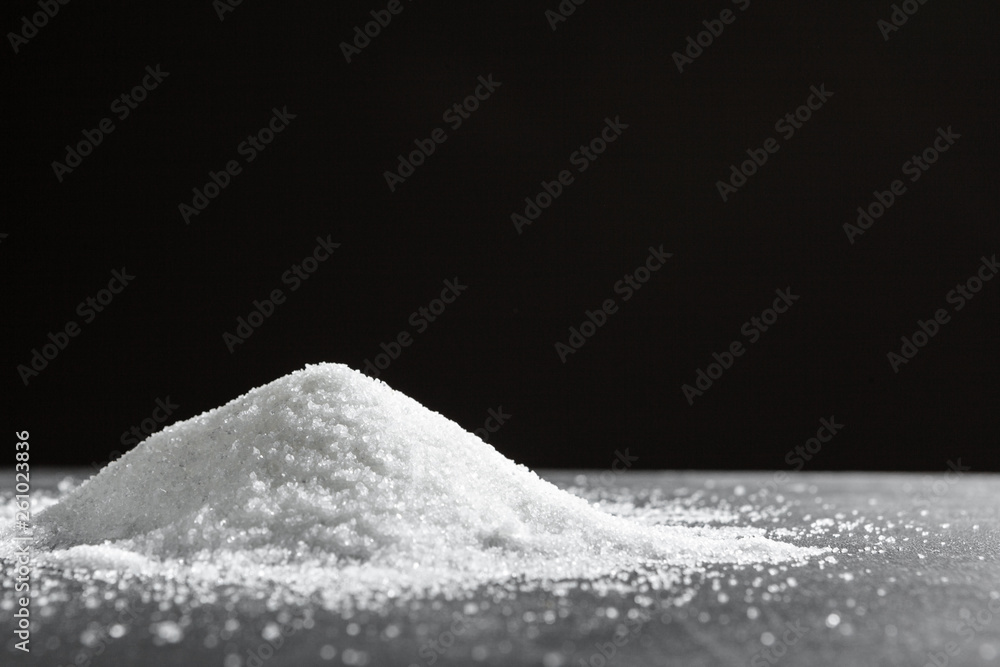 Scattered sugar on a black background close up