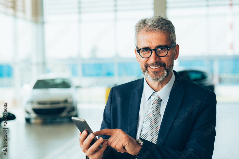 senior agent using tablet in dealers car showroom senior agent using tablet in dealers car showroom