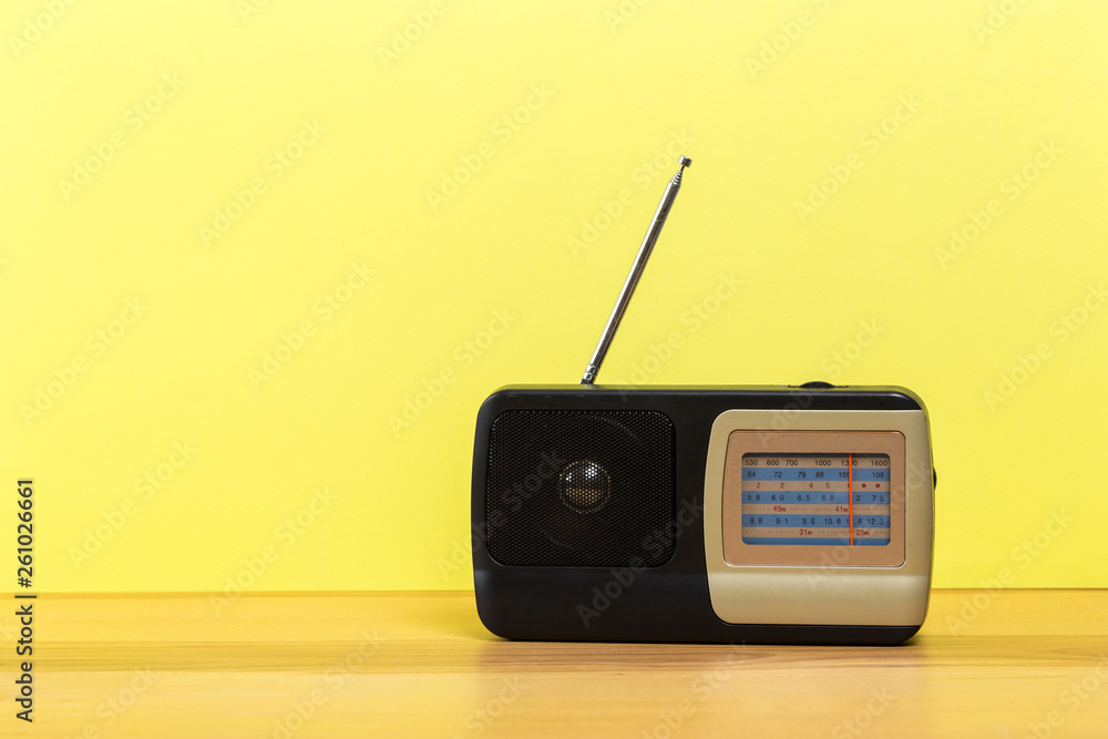 Obraz premium old radio on wooden table with color wall background