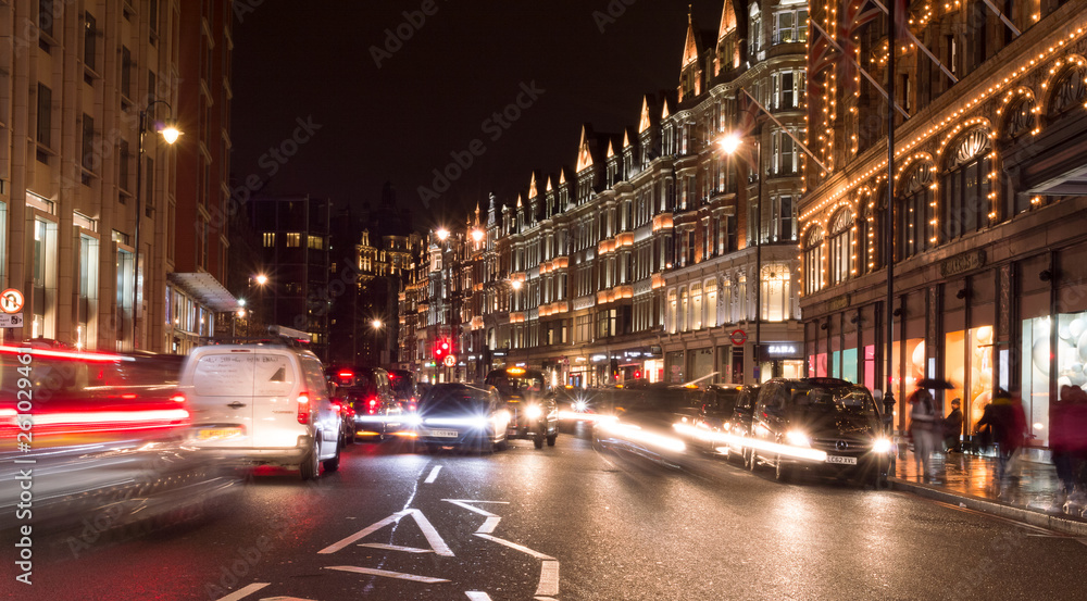London, Uk, january 2019. Night city view, a characteristic detail of the busy city life, taxis, people and wet streets.