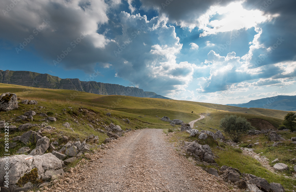 Mountain road. Landscape with rocks, sunny sky with clouds