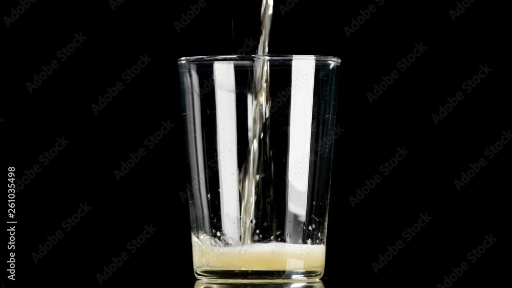 Cerveza cayendo en vaso sobre fondo negro 4k