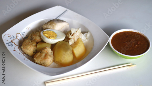 Siomay (fish cake dumplings) and peanut sauce on white background. 