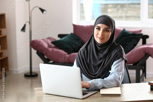 Young Muslim woman working in office © Pixel-Shot